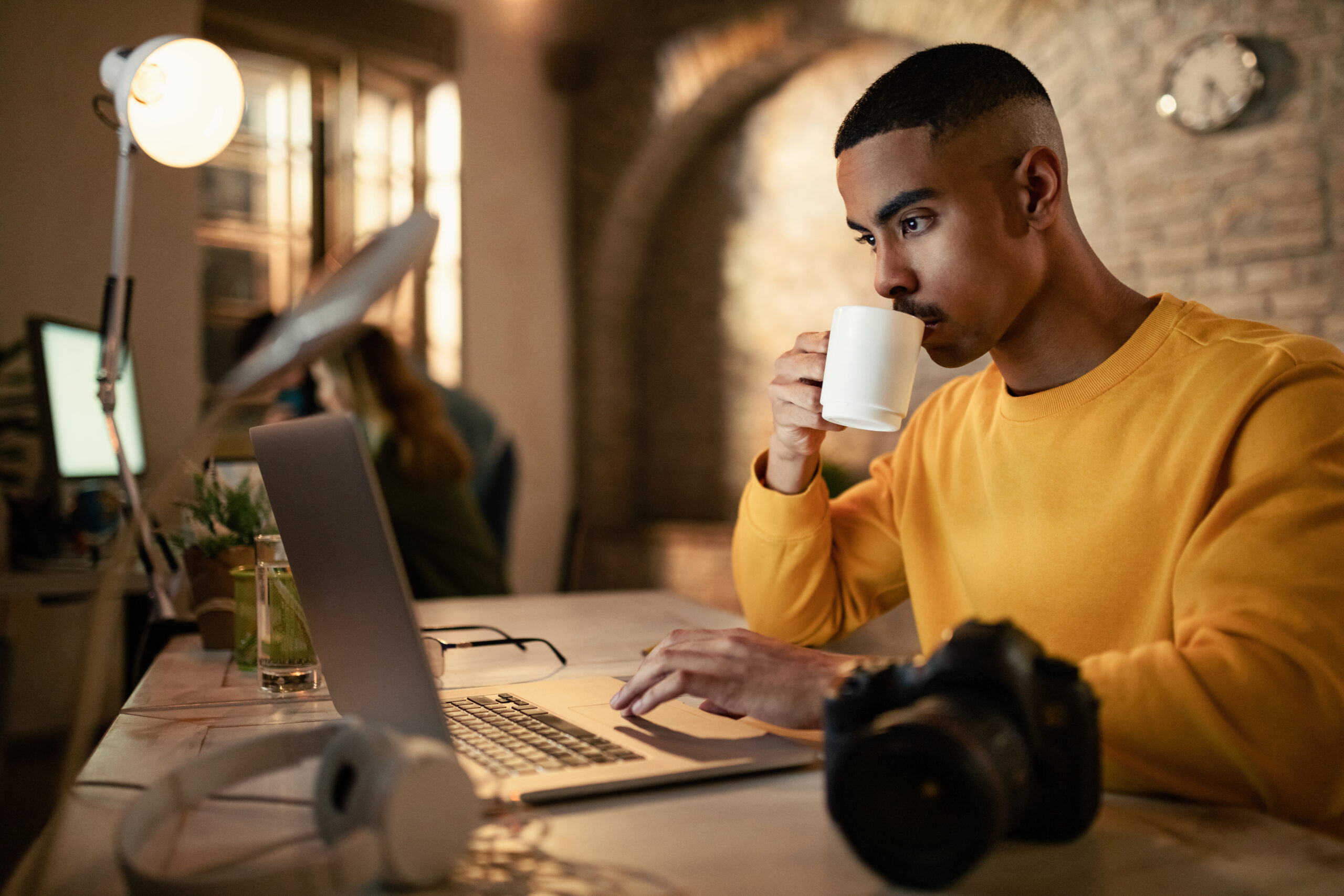 African American entrepreneur working on laptop while drinking c